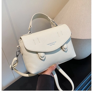 Detail of off-white lychee grain leather handbag with silver hardware and fine stitching