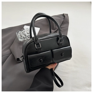 Detail of glossy black pillow bag with two buckle flap pockets and premium PU texture