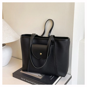 Detail view of large black tote bag with lychee texture leather and metal round buckle