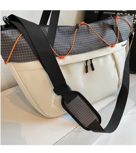 Detail view of adjustable wide shoulder strap and orange drawstring on crossbody bag