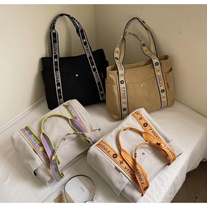 Detail of four canvas tote bags with side pockets and decorative flower patterned straps