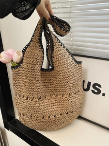 Sac fourre-tout en paille fait main avec bordure noire et texture évidée pour la plage