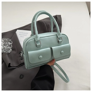 Close-up of mint green leather handbag with dual front pockets and shoulder strap