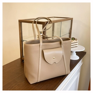 Detailed view of the khaki tote bag showing lychee grain texture and gold dot clasp