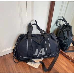 Detail der schwarzen Reisetasche aus Nylon mit JA-Logo und praktischer Netztasche