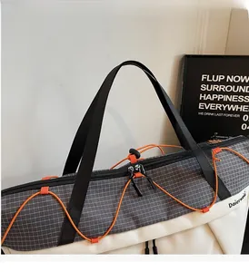 Detail shot of the durable double zippers and stylish orange drawstrings on grey fitness bag