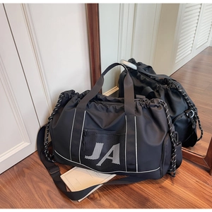 Detail der schwarzen JA-Reisetasche mit großem Fassungsvermögen auf edlem Holzboden