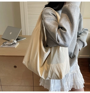 Detail of a minimalist cream white large tote bag with a soft texture on an office desk