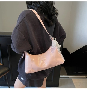 Pink glossy faux leather baguette bag with delicate white lace and pearl charm detail