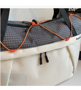 Close-up of contrast waterproof fabrics with grey grid pattern and orange elastic cord