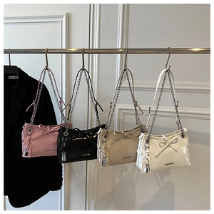 Detail of four colorful chain shoulder bags featuring bow decor and hanging locks