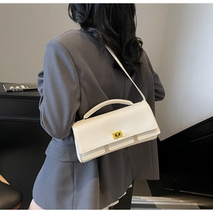 Rear view of model wearing a white rectangular handbag with golden twist lock and long strap