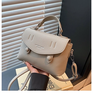 Close-up of beige lychee grain leather handbag with Fashion & Bags embossed logo detail