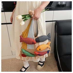Detail of knit tote bag with 3D colorful fish charms and hanging fringe tassel