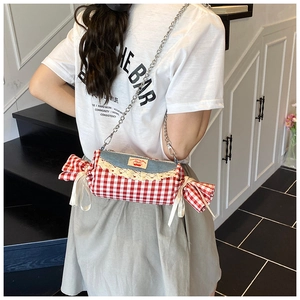 Detail of candy-shaped crossbody bag with red checkered fabric and denim lace trim