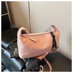 Detail of pink matte suede hobo bag with heart pendant and silver hardware zipper
