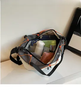 Large plaid shoulder bag interior with tablets, bottles, and organizers for storage detail