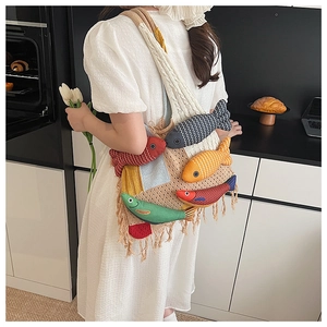 Detailed view of handmade knitted tote bag with colorful 3D fish dolls and fringe accents