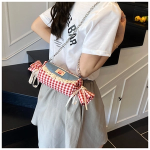 Detail of candy-shaped crossbody bag with red gingham patterns and lace cherry patchwork