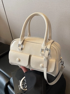 Chic cream-colored Boston shoulder bag with dual front buckle pockets and top handles