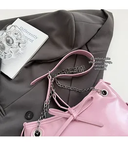 Detail of pink shoulder bag with large bow decoration and silver metal chain strap