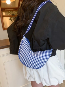 Blue and white checkered crescent crossbody bag with striped shoulder strap for women