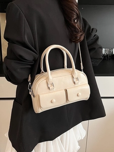 Minimalist beige leather shoulder bag with dual front pockets and sleek top handle