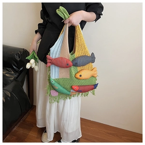 Close-up of knit tote bag featuring colorful 3D fish charms and long fringe details