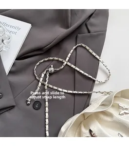 Detail of adjustable silver ball buckle on white pleated bucket bag with metal chain strap