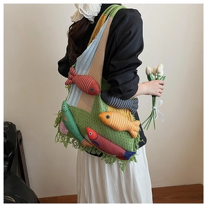 Detail of crochet tote bag with colorful 3D fish dolls and green tassels on strap