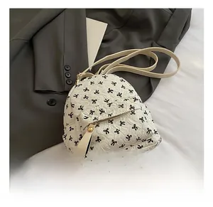 Detail showing white mini backpack with black bow print and textured leather finish