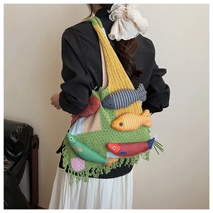 Detail of knitted tote bag with 3D colorful fish charms and stylish bottom tassels