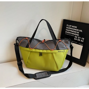 Detail view of large shoulder bag with contrast lime green base and grey checkered fabric