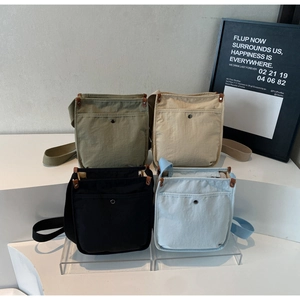 Dettaglio delle borse a tracolla in tela nei colori verde militare, beige, nero e azzurro