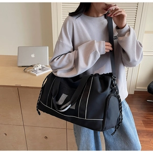 Detail einer schwarzen Nylontasche mit weißem Buchstaben N und atmungsaktiver Netztasche