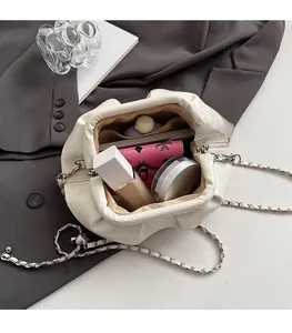 Detailed interior view of a cream pleated bucket bag showing makeup storage capacity