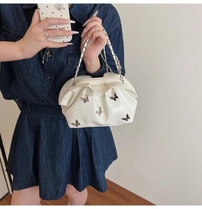 Detail of white pleated bucket bag with metallic butterfly motifs and silver chain strap