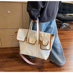 Vue détaillée du sac cabas en toile avec garniture contrastée et plusieurs poches de face