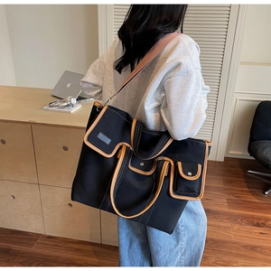 Détails d'un grand sac cabas en toile avec garniture en cuir contrasté et poches extérieures