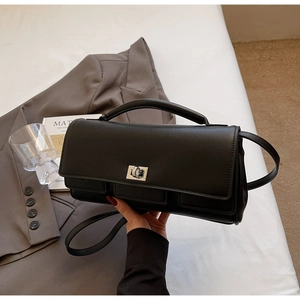 Detail of black rectangular handbag with silver rotary lock and premium leather texture