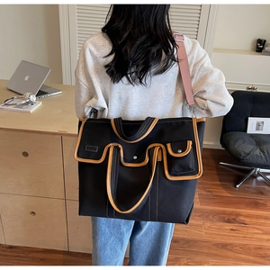 Détail du sac cabas en toile avec garniture en cuir marron et plusieurs poches