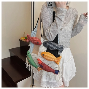 Detail of knit tote bag featuring 3D fish appliques and vibrant tassel accents