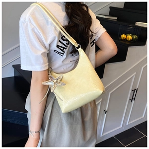 Détail du sac hobo jaune clair avec texture froissée brillante et pendentif étoile