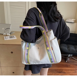 Close-up of canvas tote bag featuring floral print strap and convenient side pocket