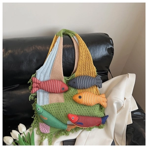 Detail of colorful knit tote bag featuring cute stuffed fish charms and fringe tassels
