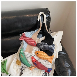 Detail of knitted tote bag featuring colorful 3D knit fish charms and fringe tassels