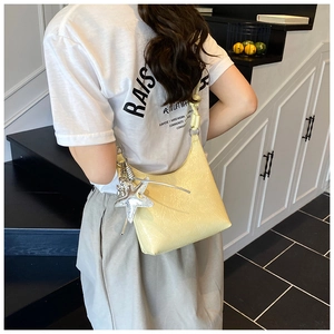 Détail du sac seau jaune avec bandoulière nouée et pendentif étoile argentée