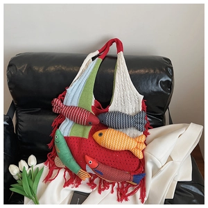 Detail view of colorful knit tote bag featuring unique 3D fish charms and long red fringes