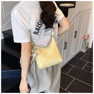 Détail du sac à bandoulière jaune pâle brillant avec pendentif étoile argentée élégant