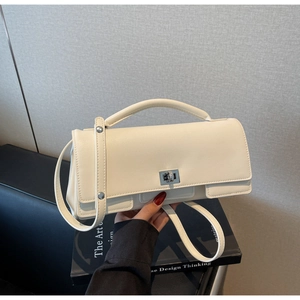 Detail of white PU leather box bag featuring a silver twist lock and adjustable strap